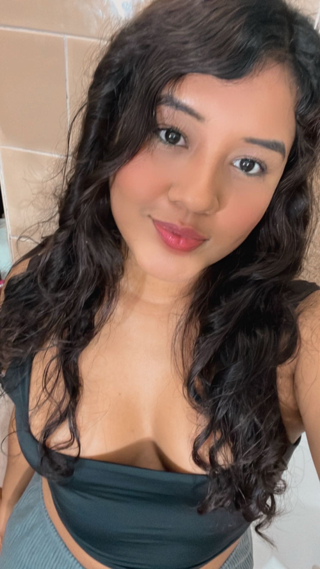 Girl with curly hair smiling on a cam to cam chat